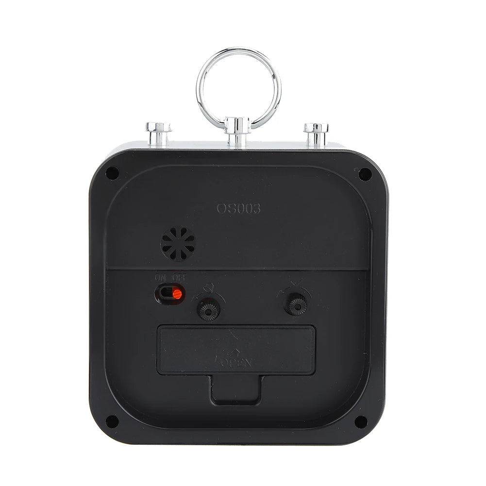 Arrière du réveil carré gris, panneau noir avec réglages et interrupteur rouge.