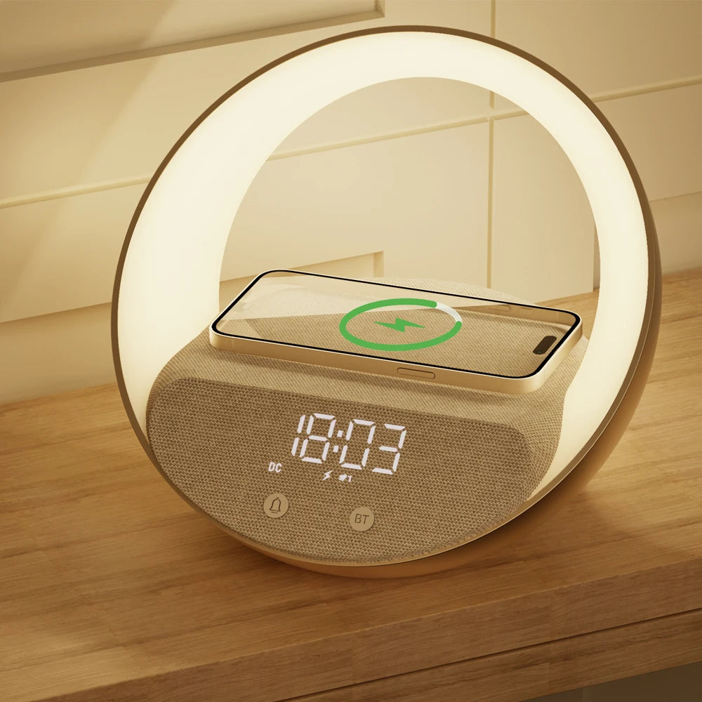 Un Doux Reveils Réveil Connecté 4-en-1 avec écran numérique, haut-parleur Bluetooth, lampe RGB et chargeur sans fil est posé sur du bois. Un smartphone se recharge sans fil sur le dessus, indiqué par une icône, tandis que l'anneau LED de l'horloge ajoute une touche de modernité.