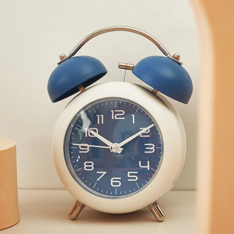 reveil-enfant-7ans-metal-silencieux-double-cloche-bleu-vintage a coté d'un objet beige