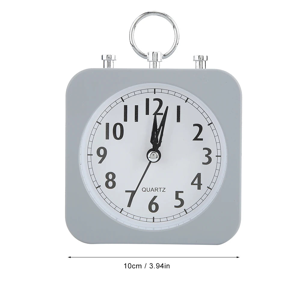 Réveil carré gris avec cadran blanc et chiffres noirs, dimensions indiquées en centimètres et pouces.