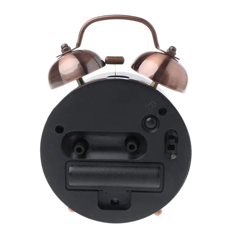 Réveil vintage en métal avec double cloche vu de dos – compartiment à piles et interrupteur.