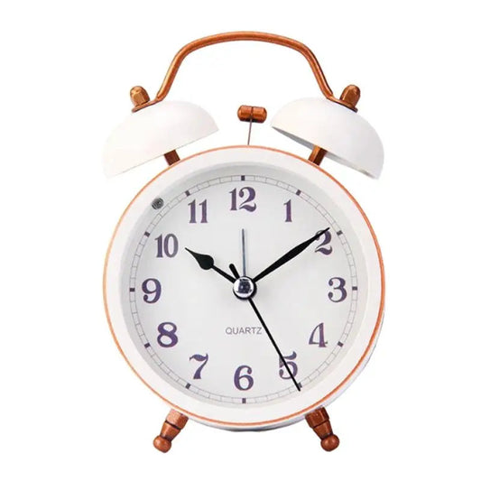 Réveil vintage blanc à double cloche cuivrée, cadran blanc avec chiffres noirs.