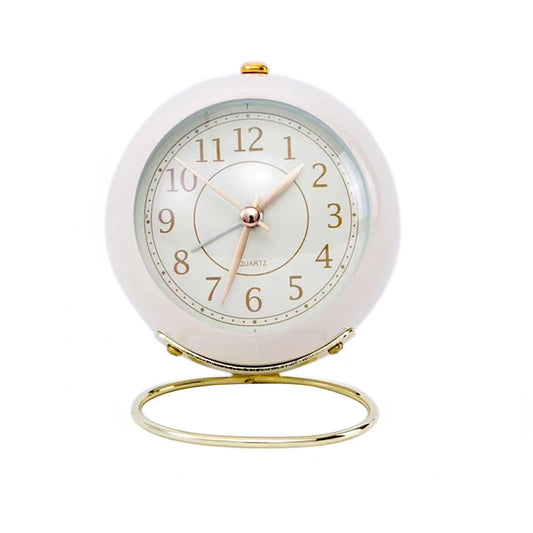  Réveil Vintage Silencieux Rond blanc crème sur fond uni, mettant en valeur son support doré raffiné.