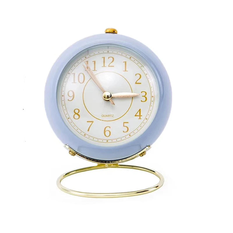  Réveil Vintage Silencieux Rond Bleu crème sur fond uni, mettant en valeur son support doré raffiné.