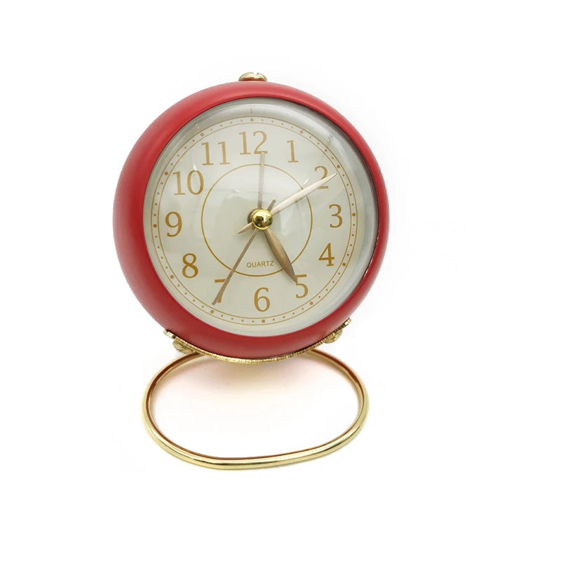  Réveil Vintage Silencieux Rond Rouge crème sur fond uni, mettant en valeur son support doré raffiné.